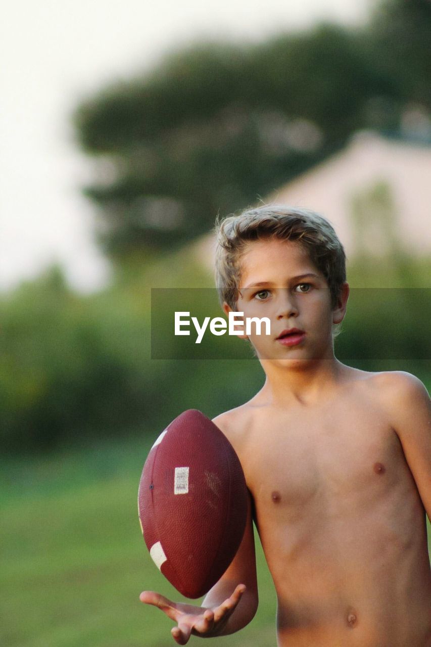 Portrait of shirtless boy holding ball