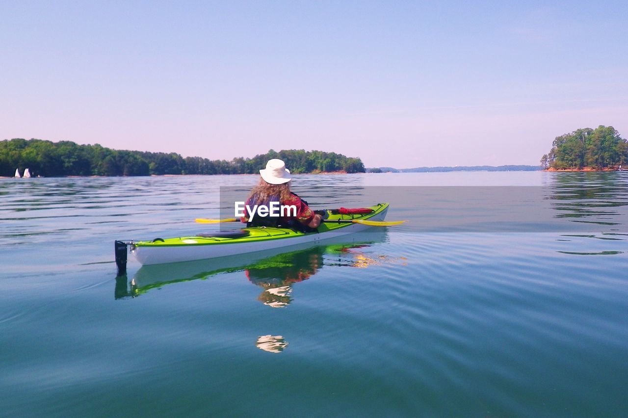 Rear view of woman kayaking in river