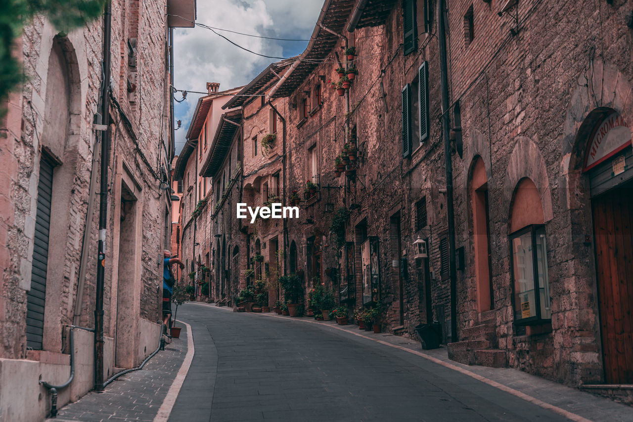 Empty road amidst buildings in city