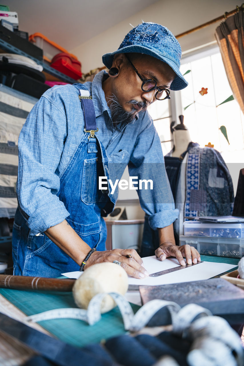 Man working over fabric on table