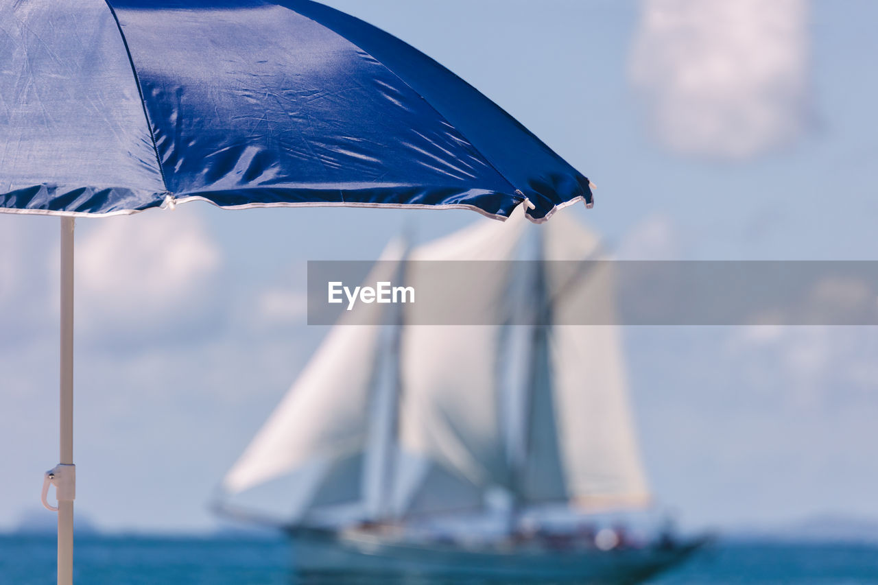 Blue umbrella at beach against sky during sunny day