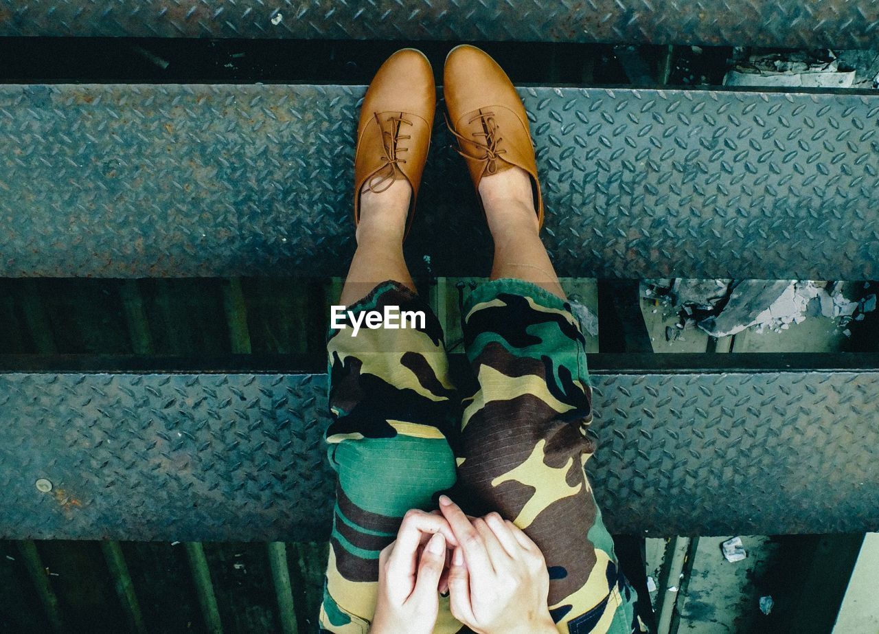 Upside down image of woman wearing shoes while sitting on steps