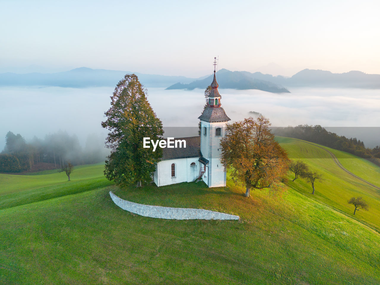 Aerial drone shot of sveti tomaž church in Škofja loka in slovenia on a misty morning