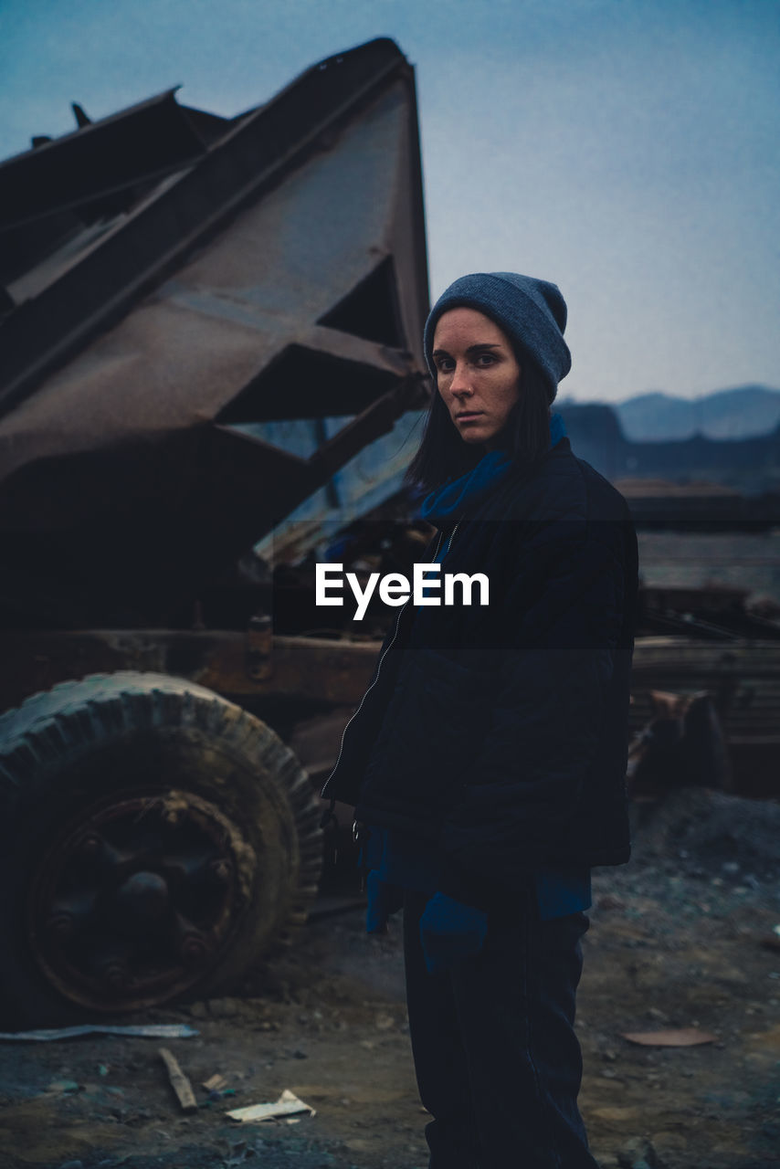 Portrait of young women standing against car