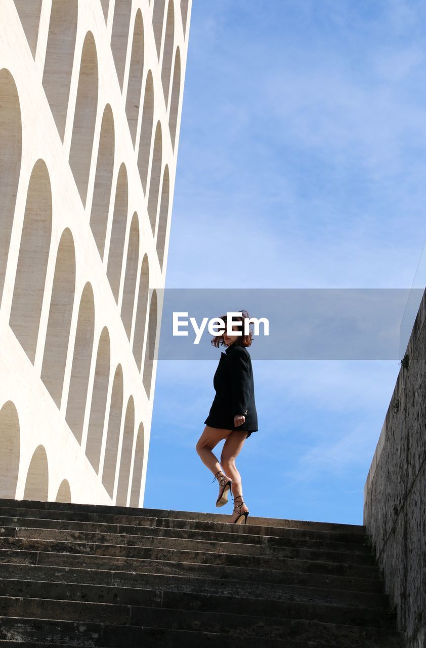 Low angle view of woman walking on steps