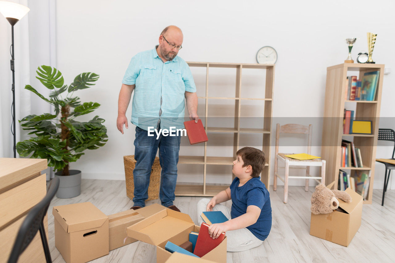 portrait of smiling family standing in cardboard box