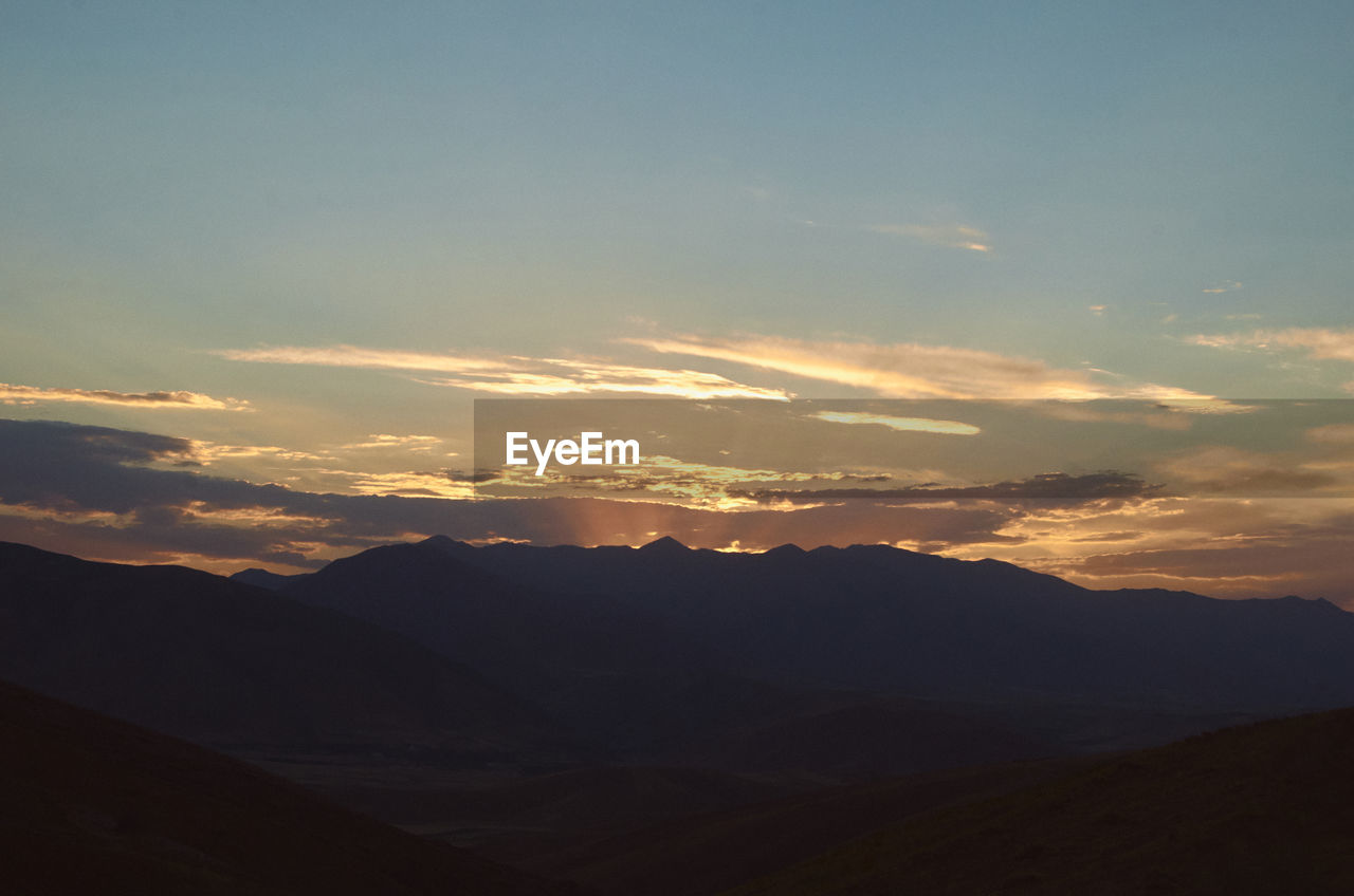 SCENIC VIEW OF SILHOUETTE MOUNTAIN AGAINST SKY DURING SUNSET