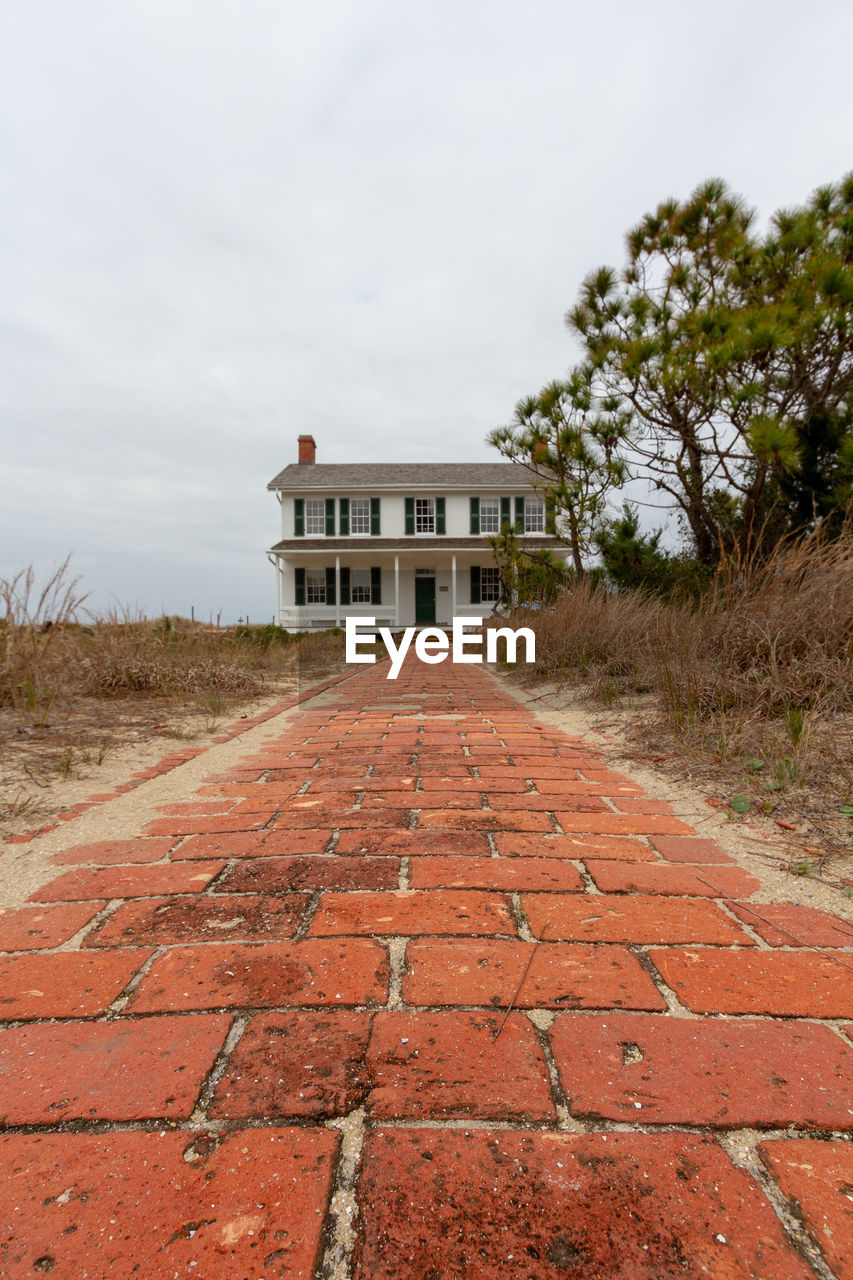 ROAD BY BUILDING AGAINST SKY