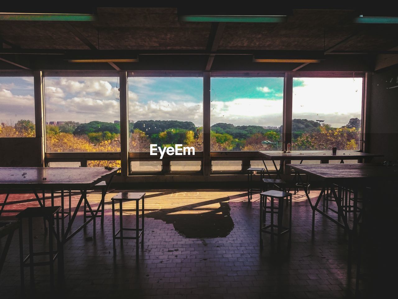 Empty chairs and tables by glass windows