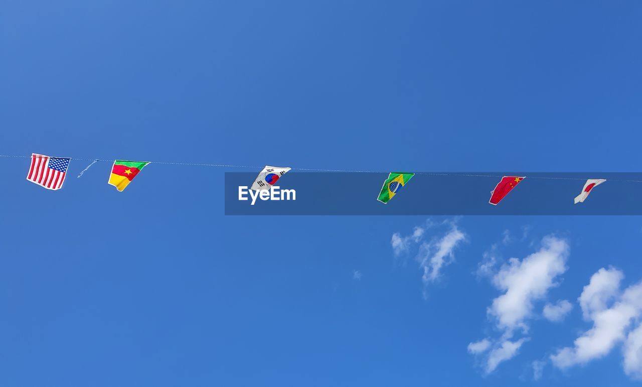 LOW ANGLE VIEW OF FLAG FLAGS AGAINST BLUE SKY