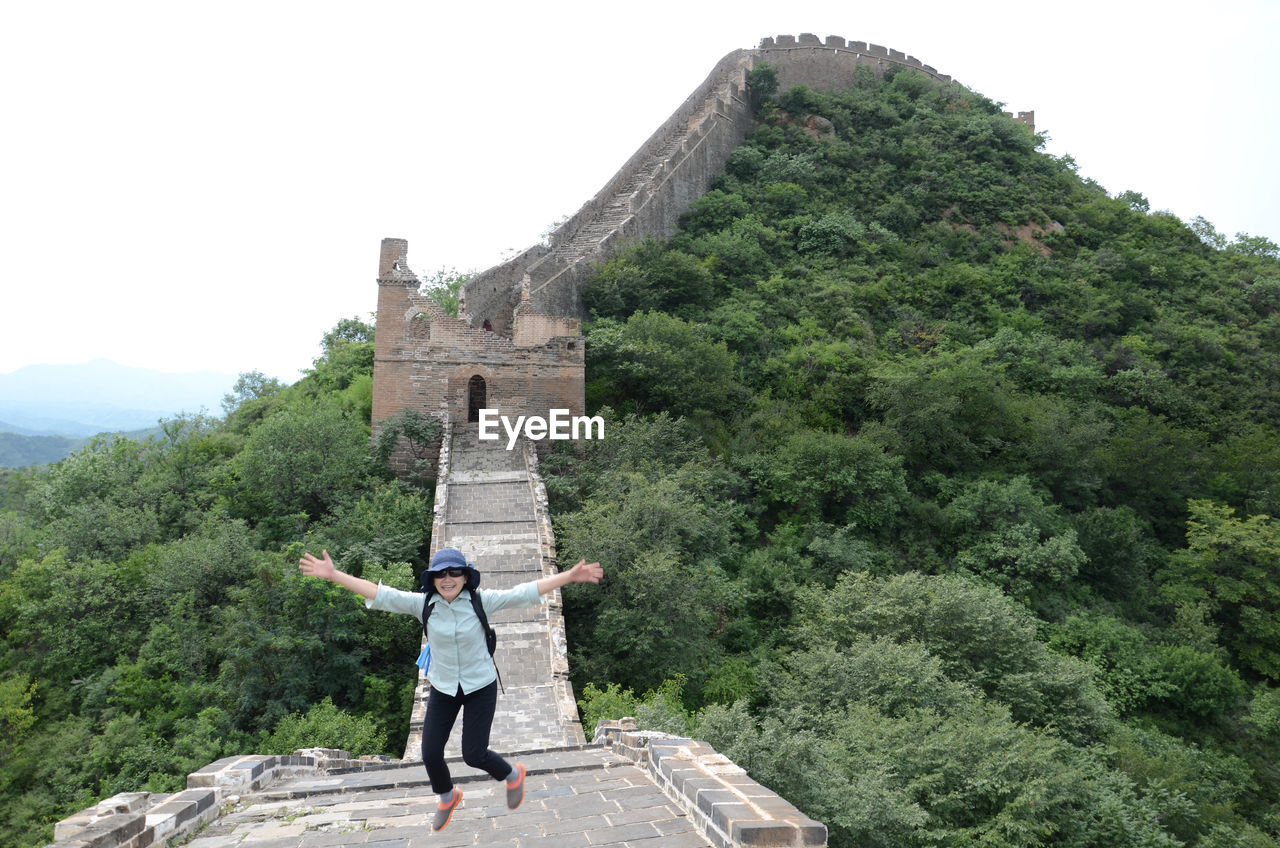 High angle view of woman jumping on great wall of china