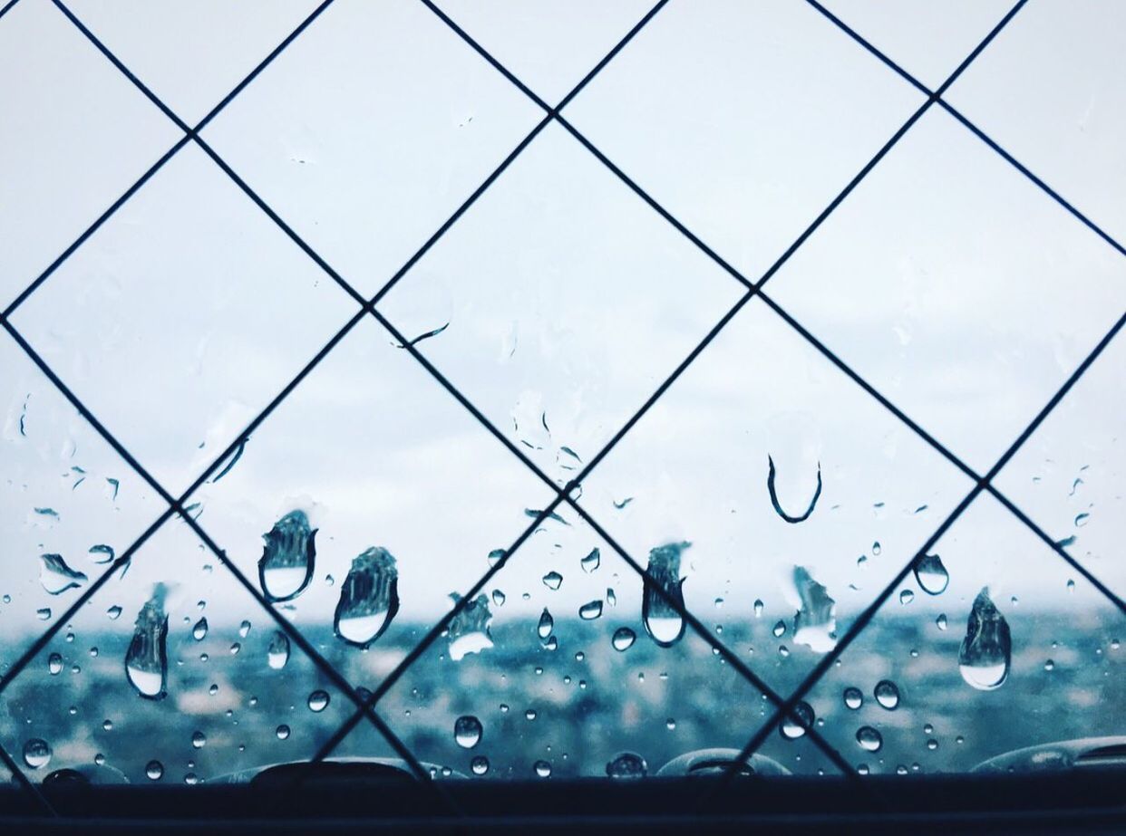 Wet glass window against sky