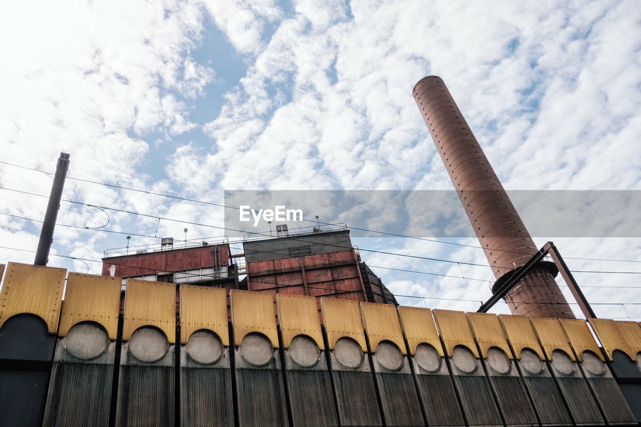 Low angle view of smoke stack against sky