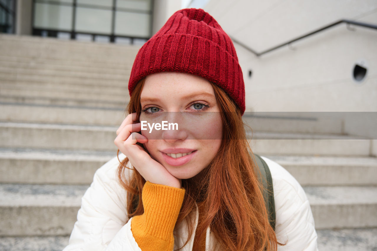 portrait of young woman wearing hat standing outdoors