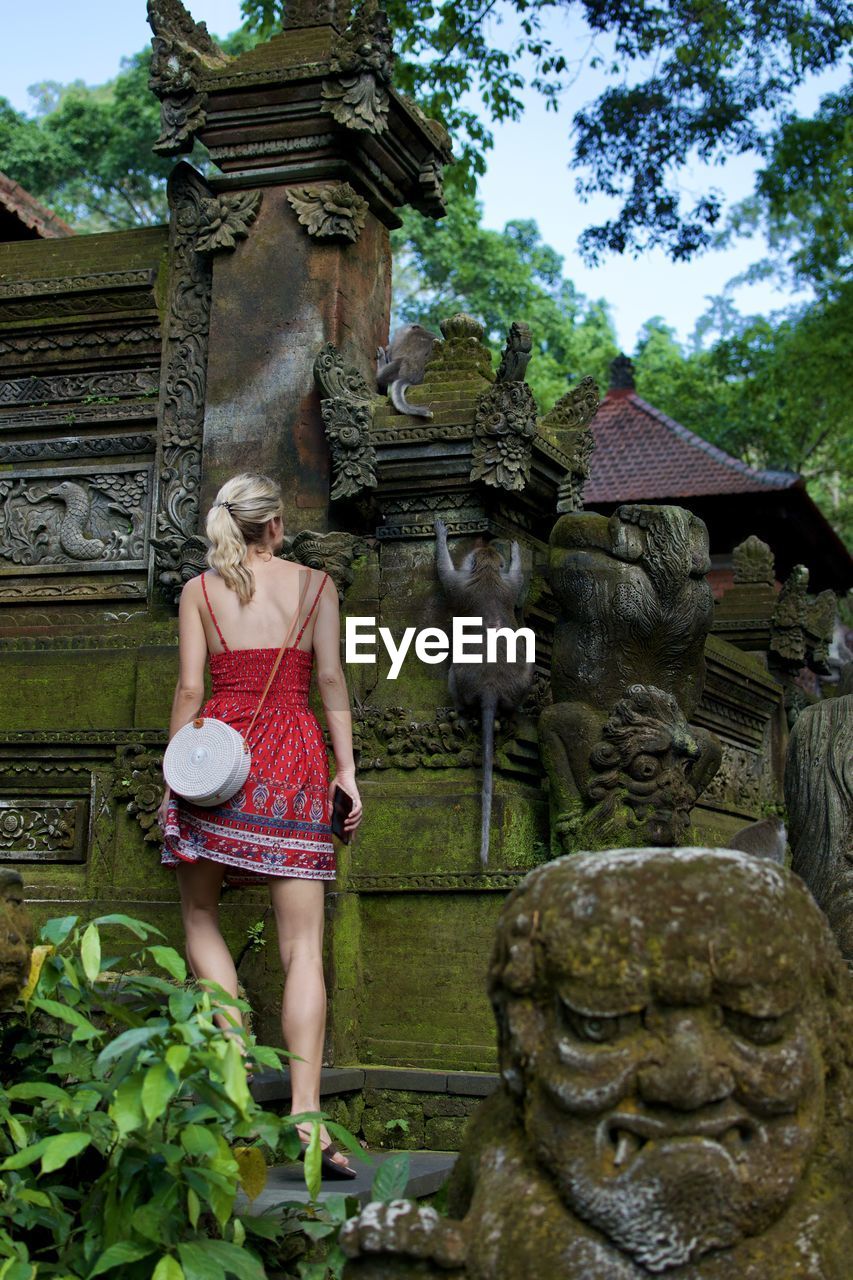 Rear view of woman standing by old built structure