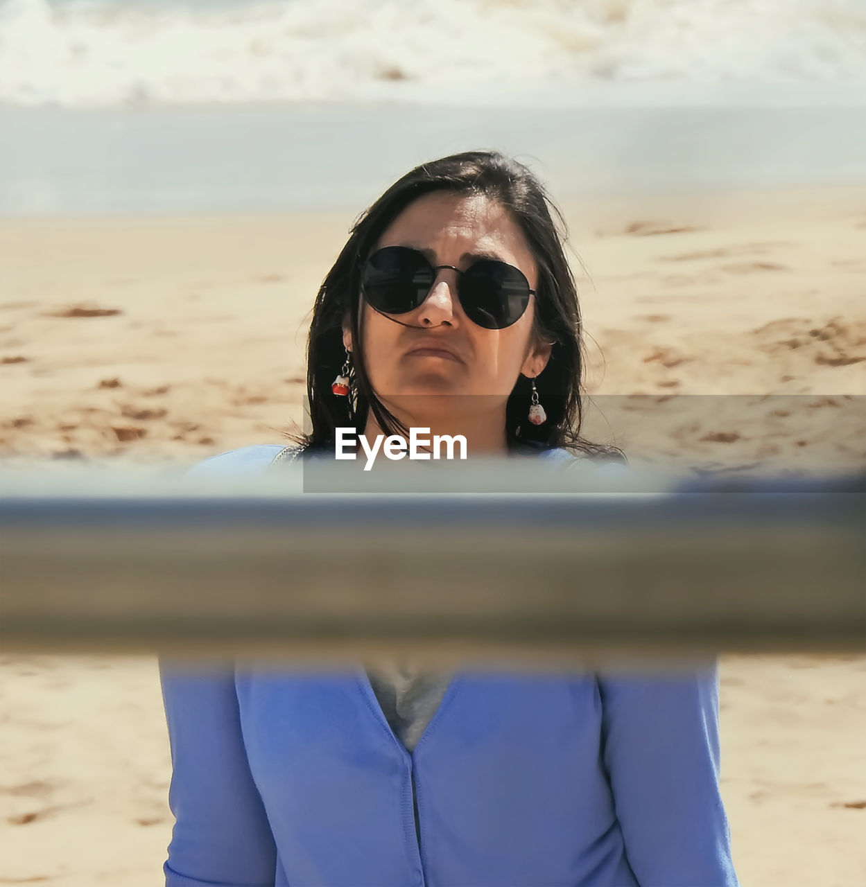 Portrait of young woman wearing sunglasses standing at beach