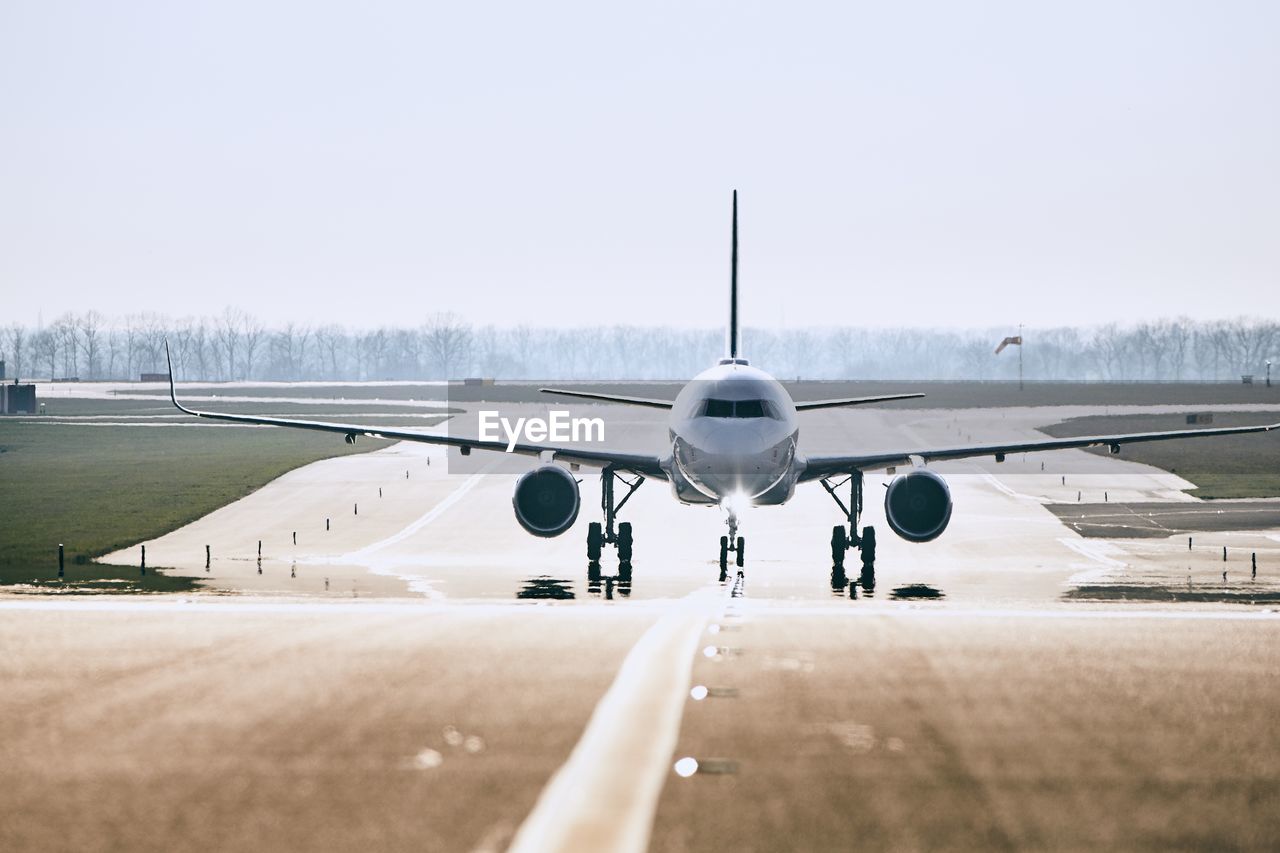 Airplane on runway against clear sky