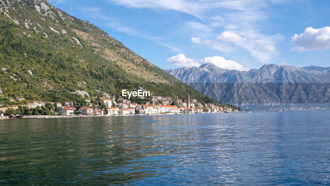 Scenic view of lake by mountain against sky