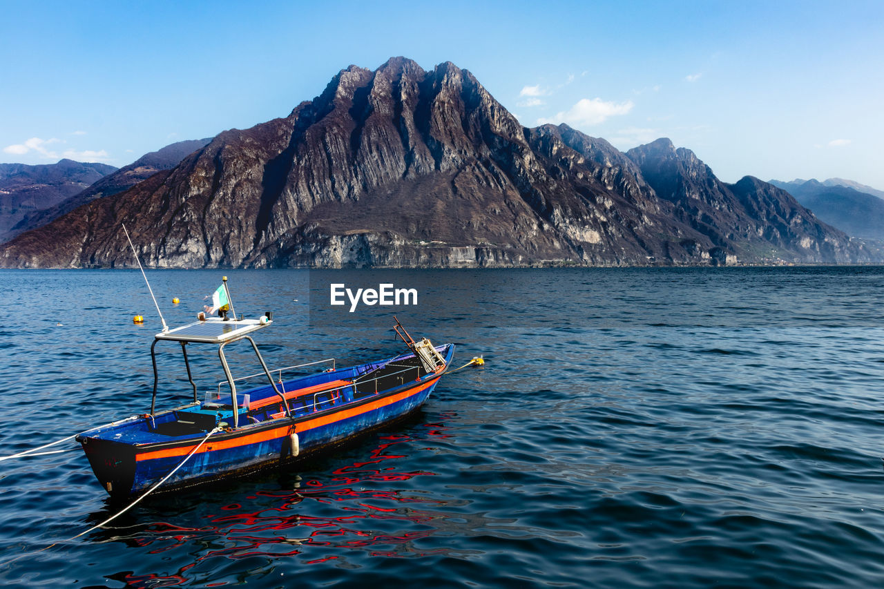 Scenic view of lake by mountains against sky