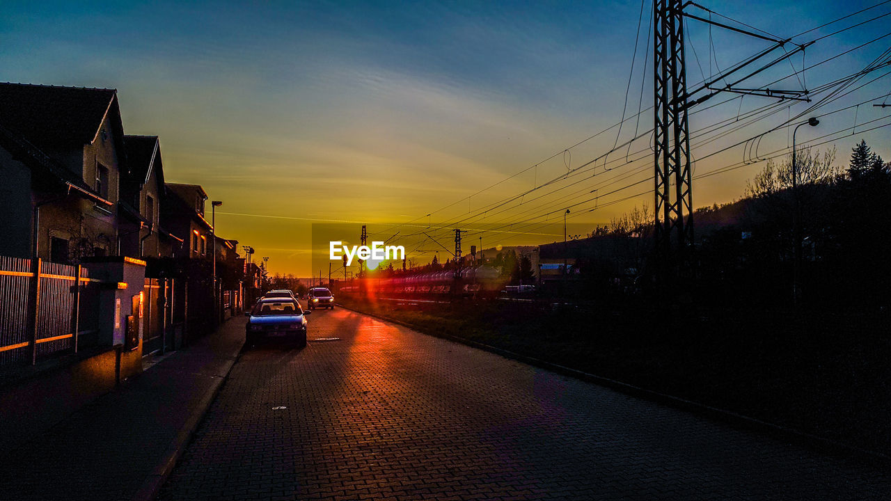 CARS ON STREET IN CITY DURING SUNSET