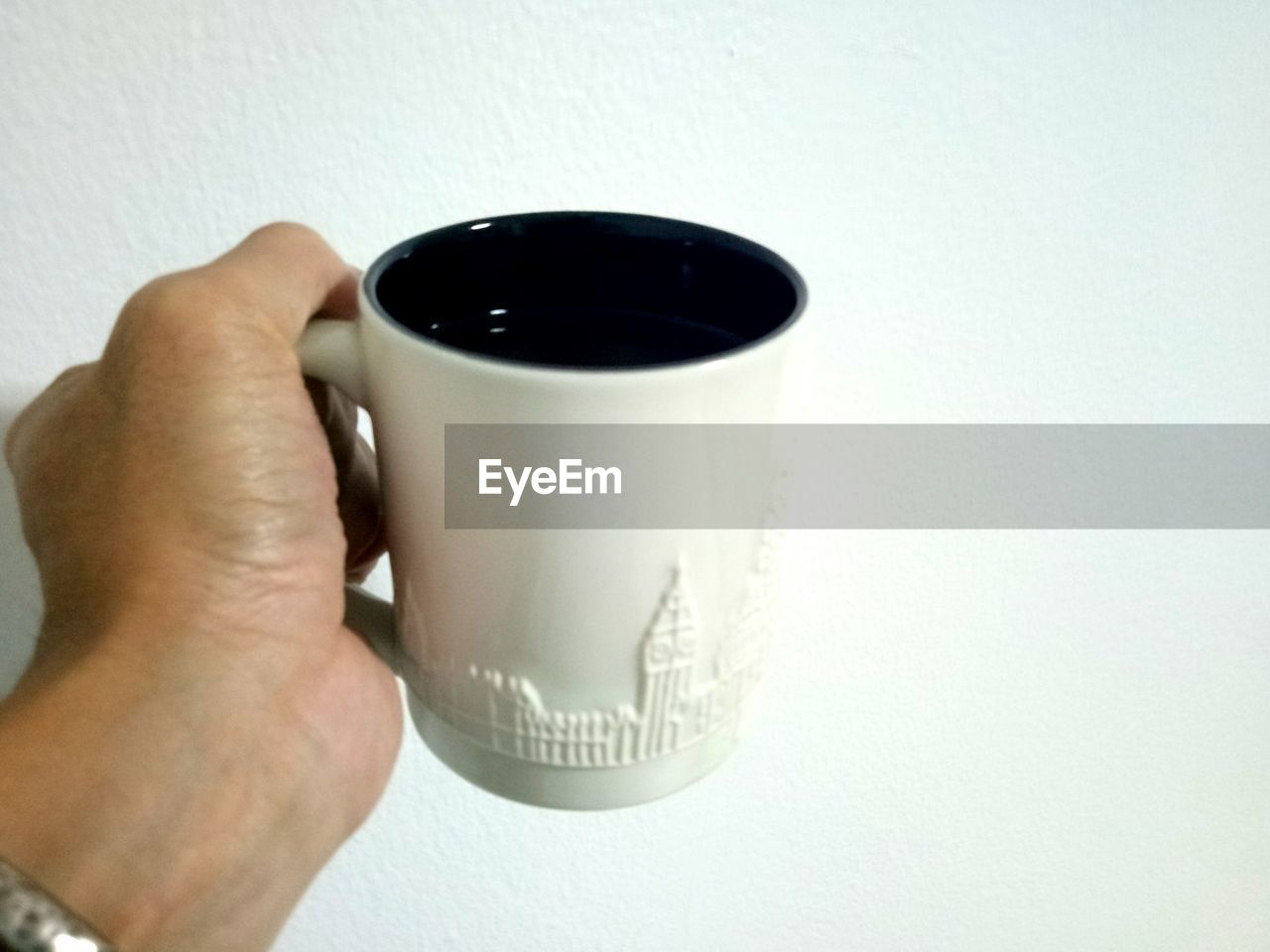 CROPPED IMAGE OF HAND HOLDING COFFEE CUP WITH SPOON
