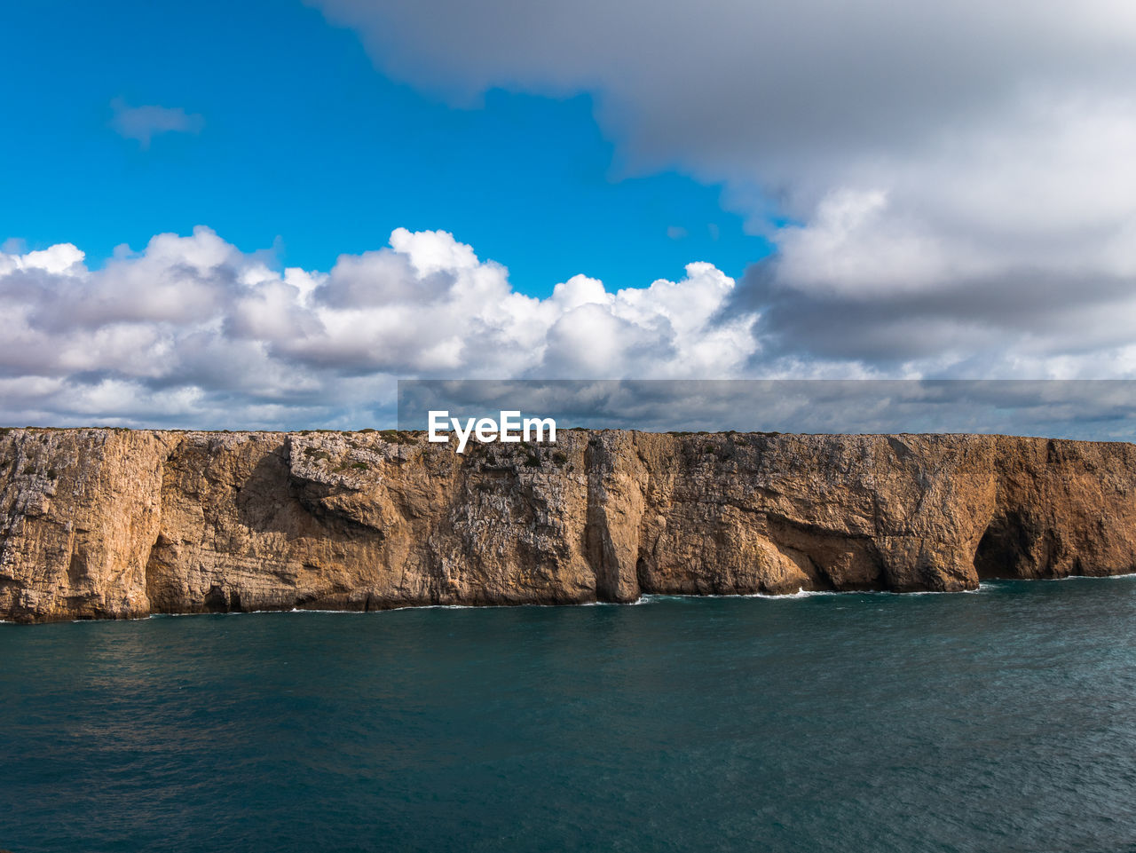 Panoramic view of rocks and sea against sky