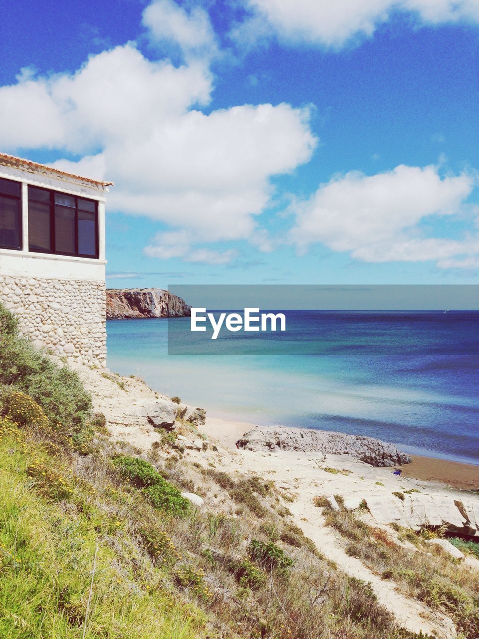 Scenic view of blue sea against cloudy sky