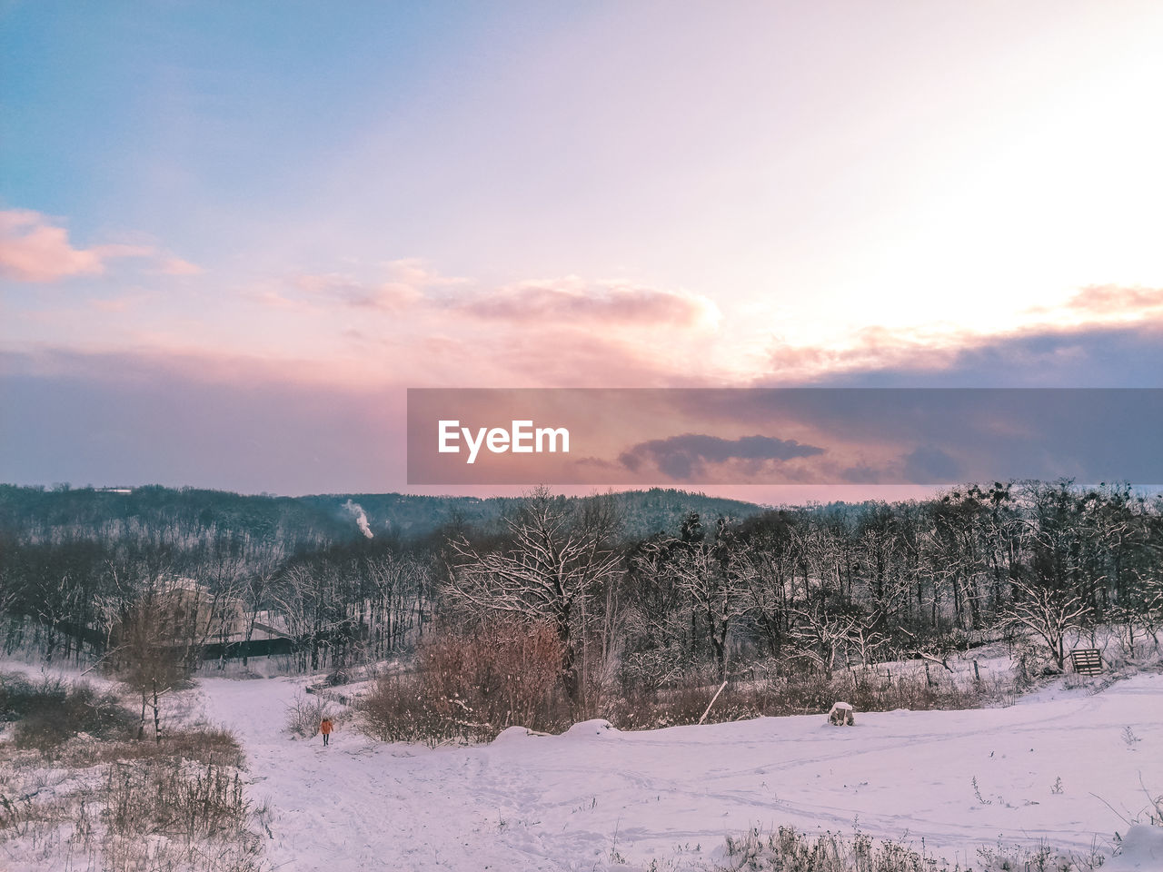 SCENIC VIEW OF SNOW COVERED LAND AGAINST SKY AT SUNSET