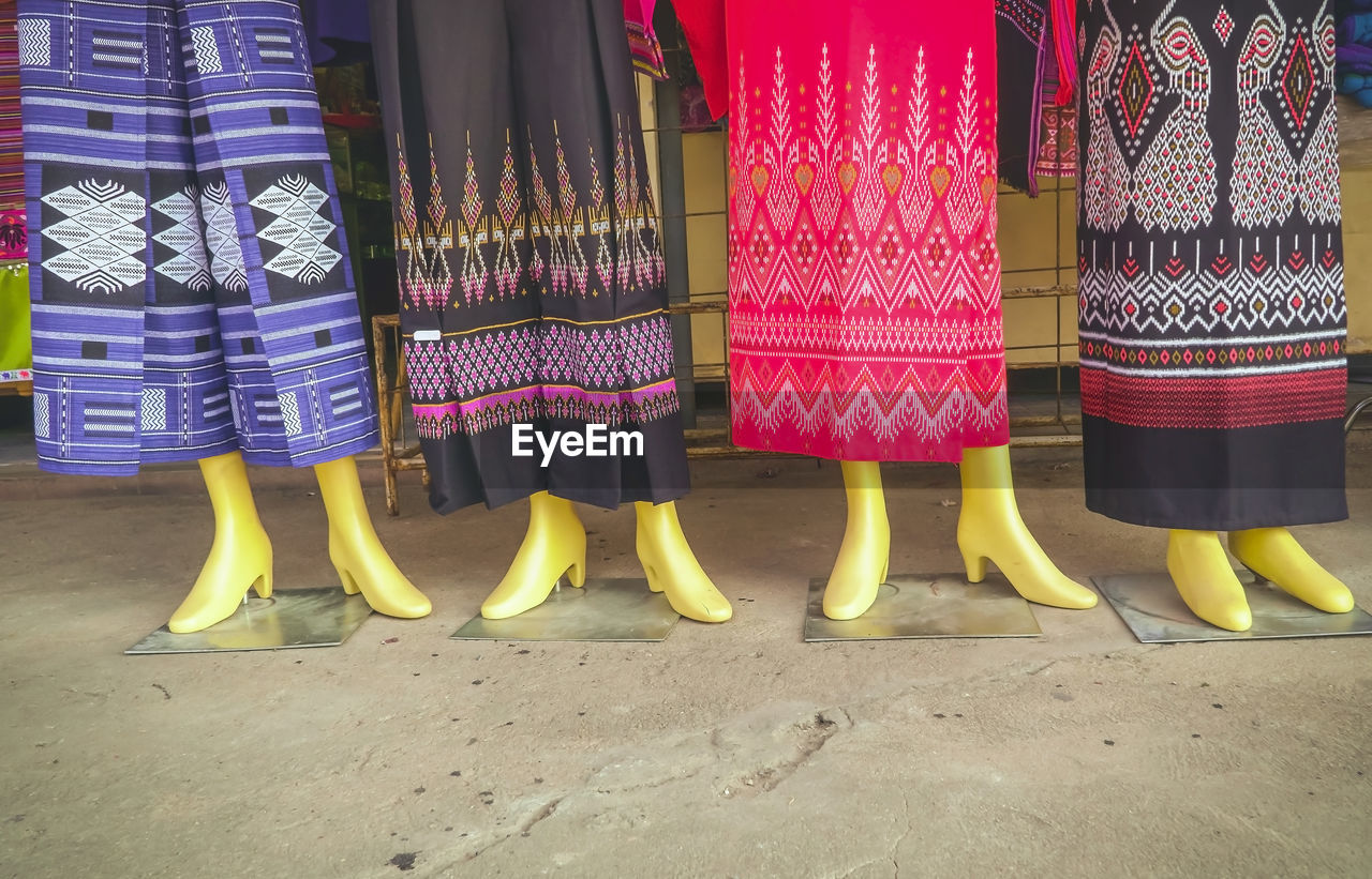 Low section of textile displayed on mannequins for sale at market