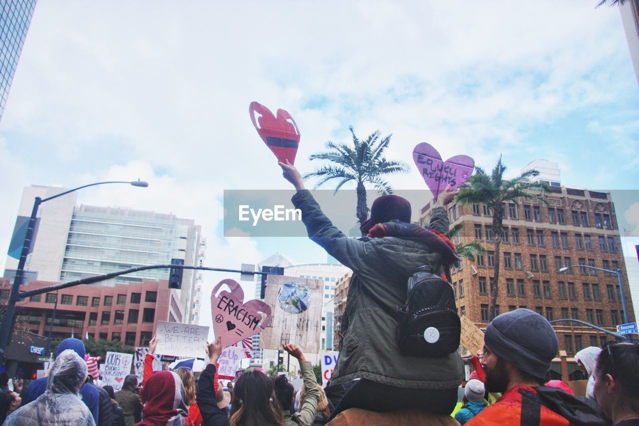 LOW ANGLE VIEW OF PEOPLE AGAINST SKY