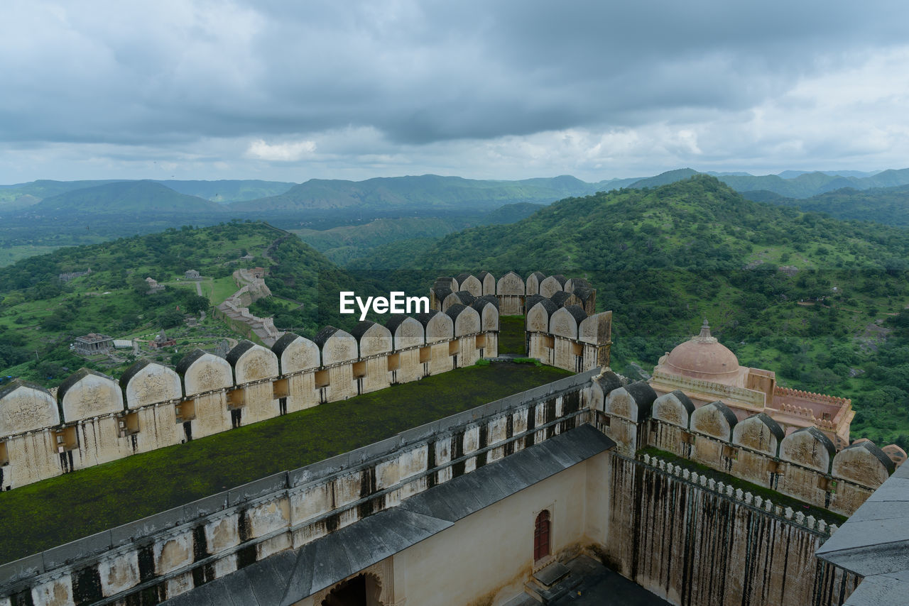 architecture, built structure, history, environment, the past, cloud, travel destinations, sky, mountain, landmark, nature, travel, landscape, tourism, scenics - nature, building exterior, ancient, tree, city, plant, beauty in nature, no people, outdoors, building, high angle view, mountain range, fog, tranquility, overcast, land, religion, day, water, railing, wall, fortified wall, forest