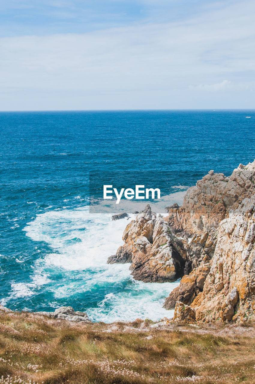 SCENIC VIEW OF ROCKS ON BEACH AGAINST SKY