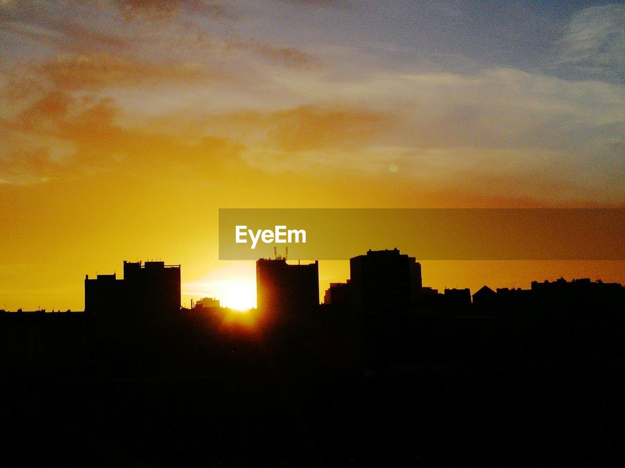 Silhouette buildings against sky during sunset