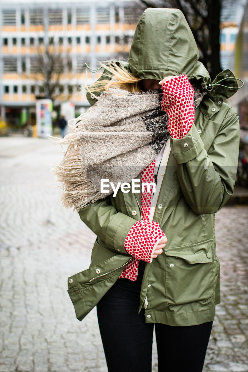 Portrait of woman walking protecting herself from wind