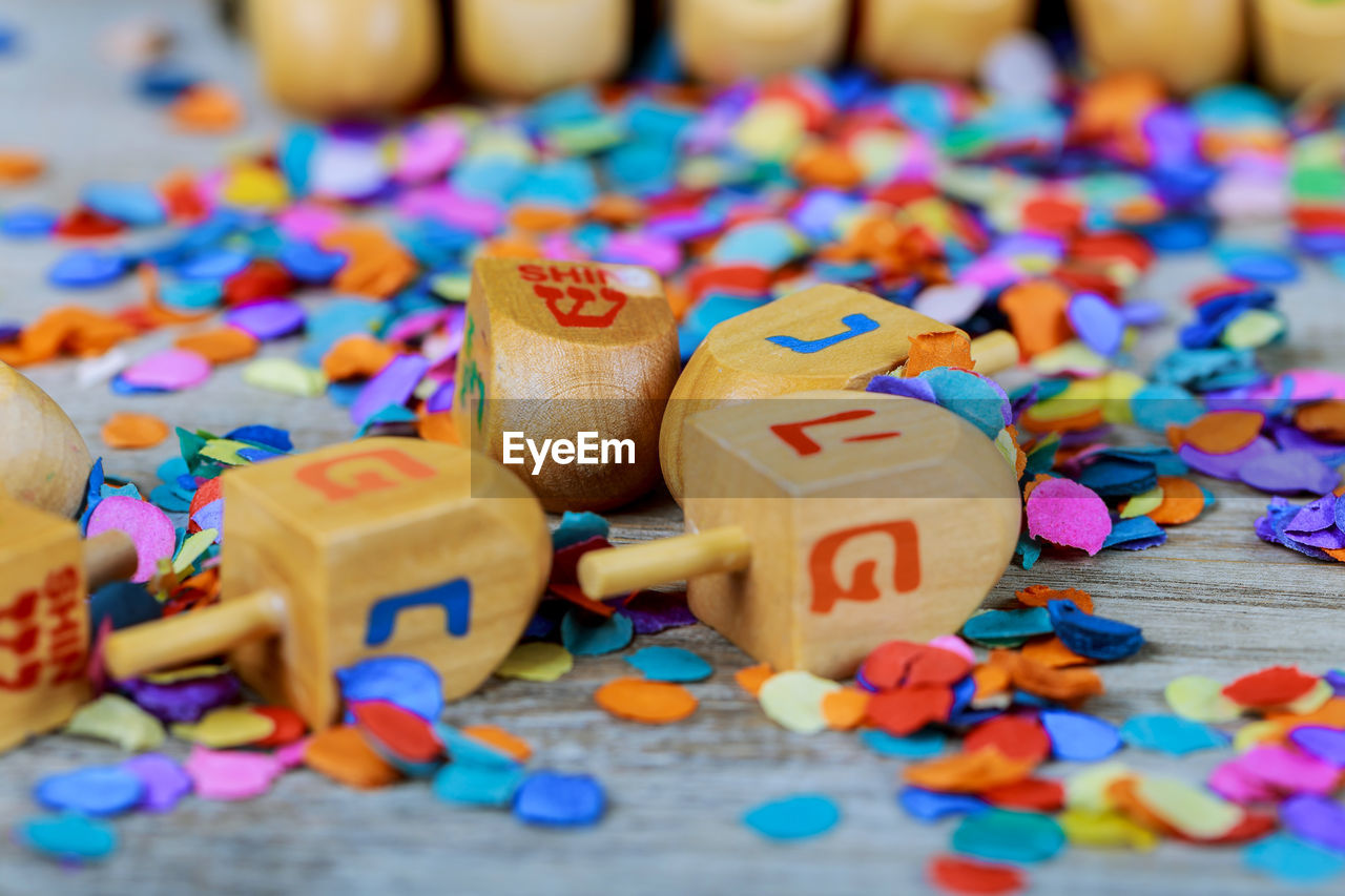 High angle close-up of toy blocks with colorful confetti on wooden table