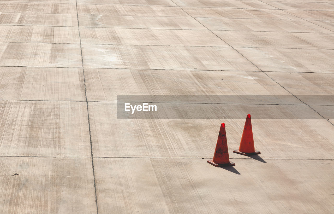 High angle view of traffic cones at concrete runway on sunny day