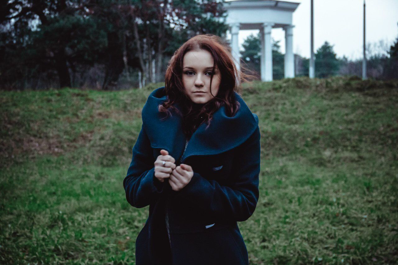 Portrait of woman standing on grassy field