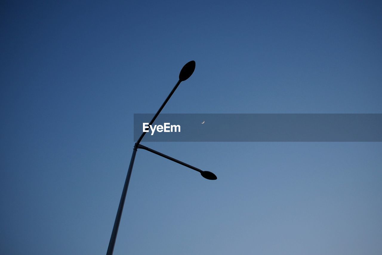 LOW ANGLE VIEW OF MOON IN CLEAR BLUE SKY