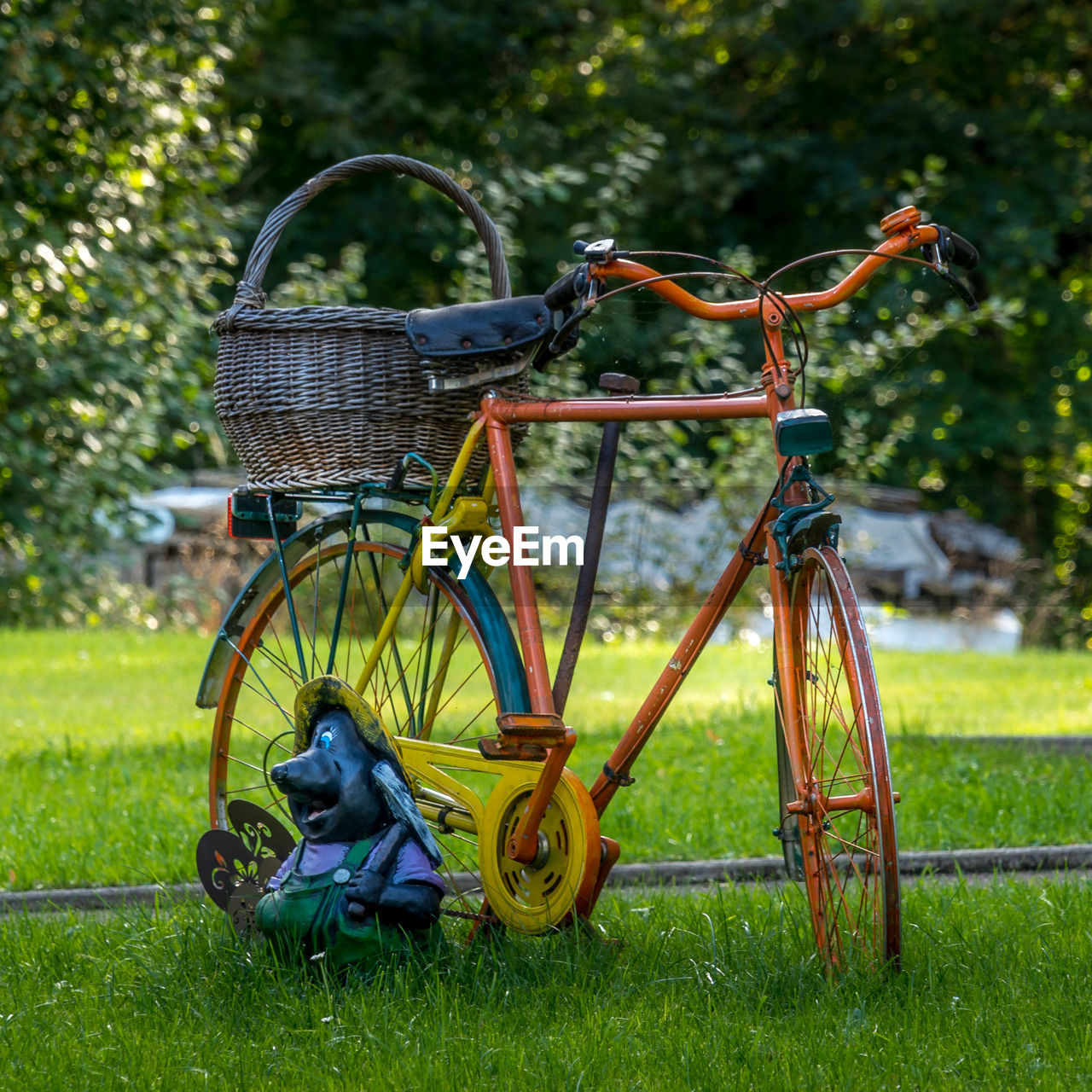 Orange bicycle in basket on field