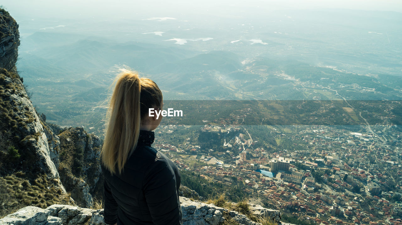 High angle view of woman looking at cityscape from mountain
