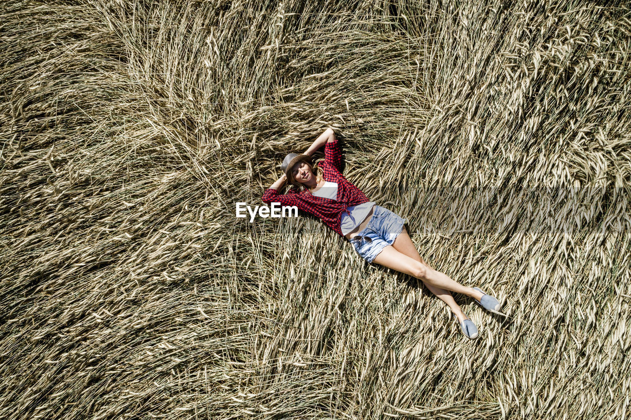 Portrait of woman lying on hay