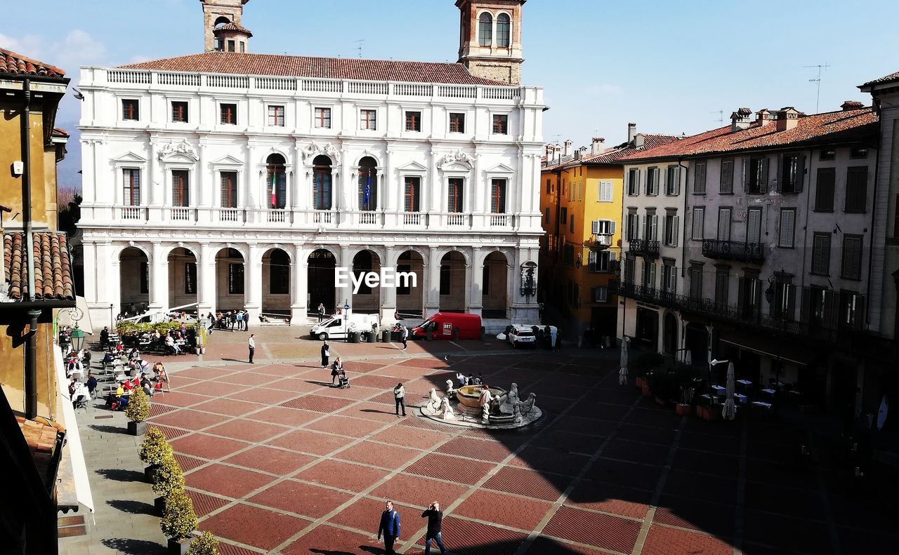 GROUP OF PEOPLE IN FRONT OF BUILDINGS