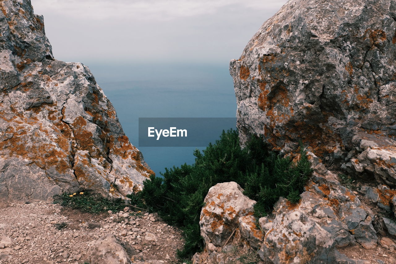 Rock formations by sea against sky