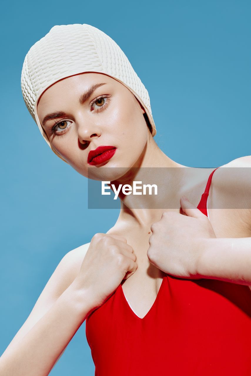 low angle view of young woman with eyes closed against blue background