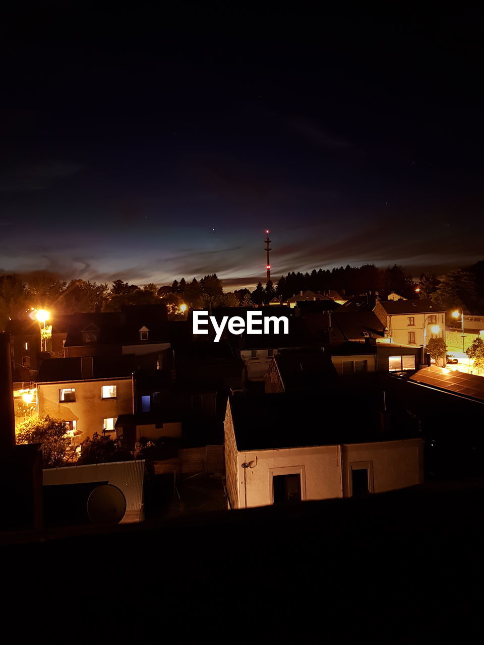 Illuminated cityscape against sky at night