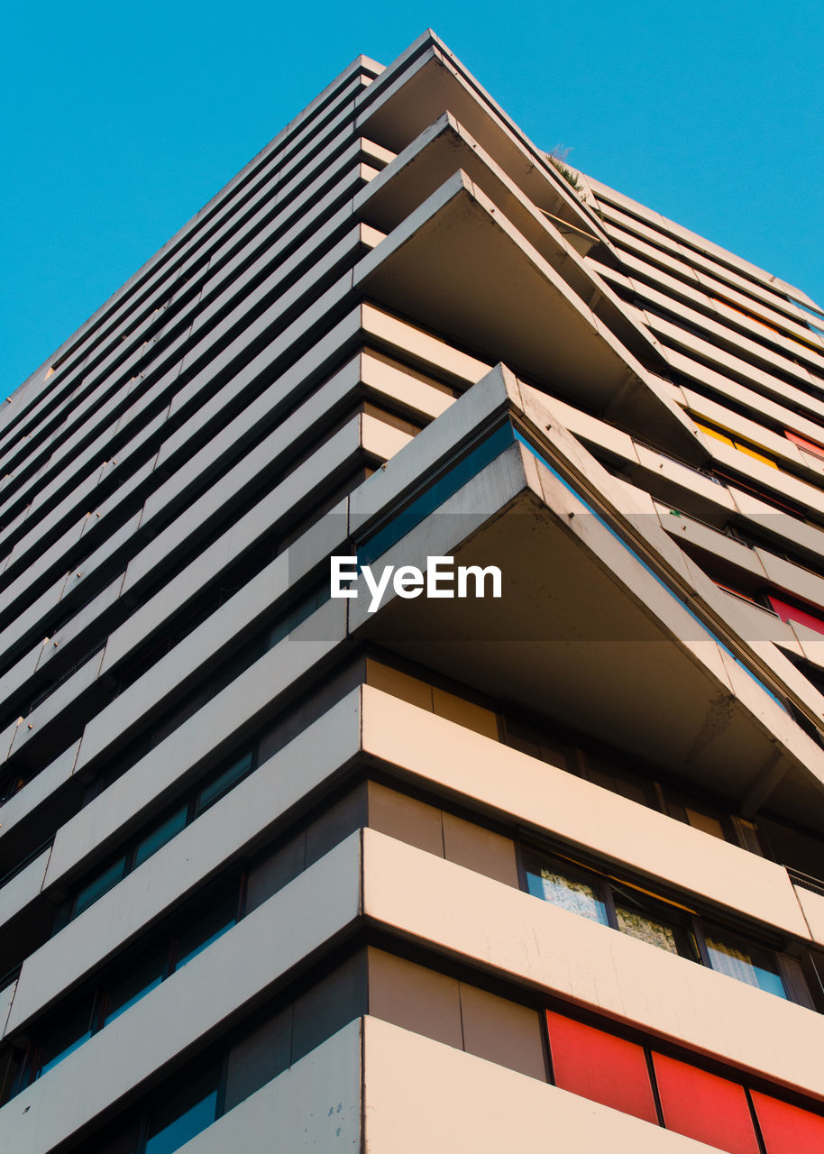 Low angle view of modern building against clear blue sky