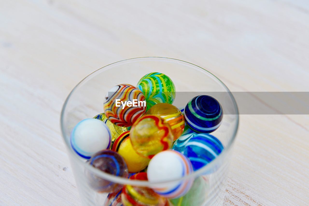 HIGH ANGLE VIEW OF MULTI COLORED CANDIES ON TABLE
