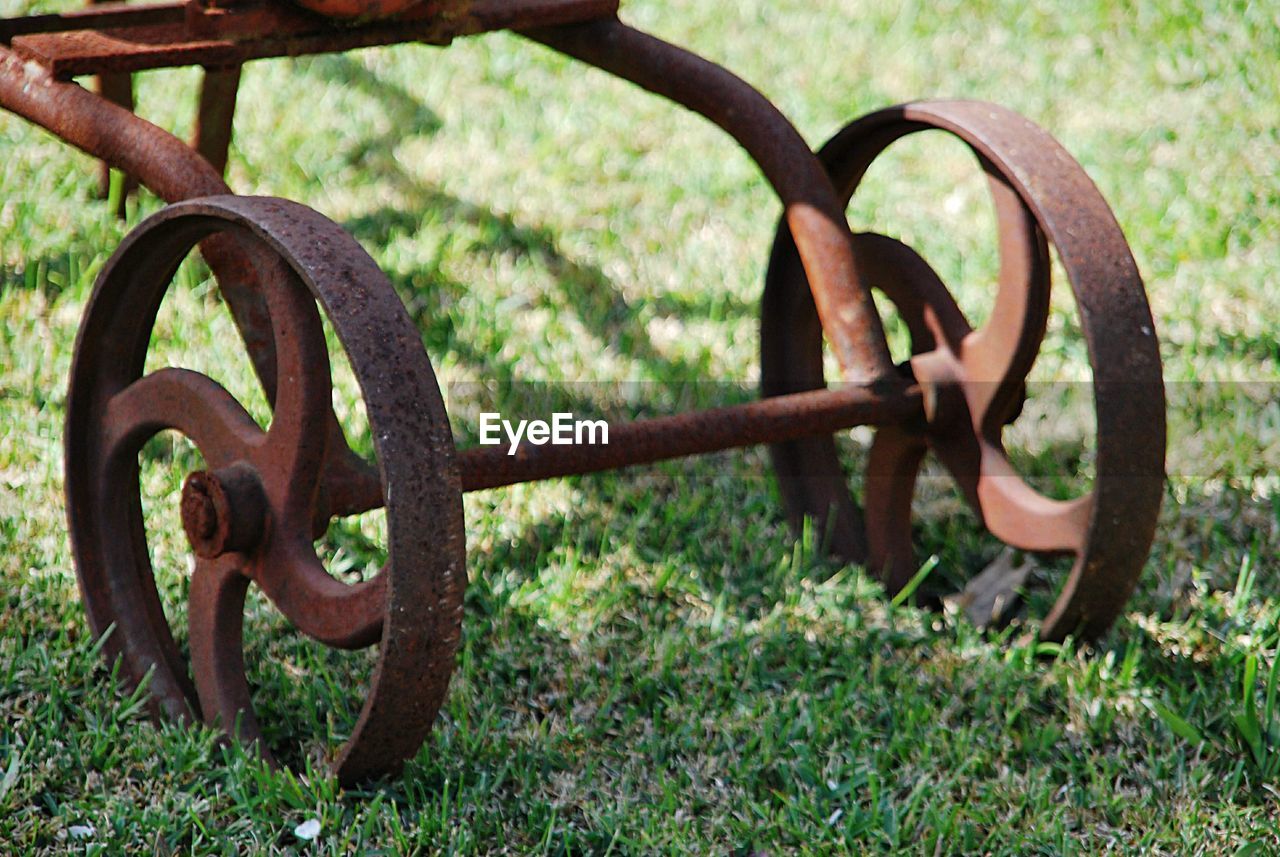 Close-up of rusty machine part on field