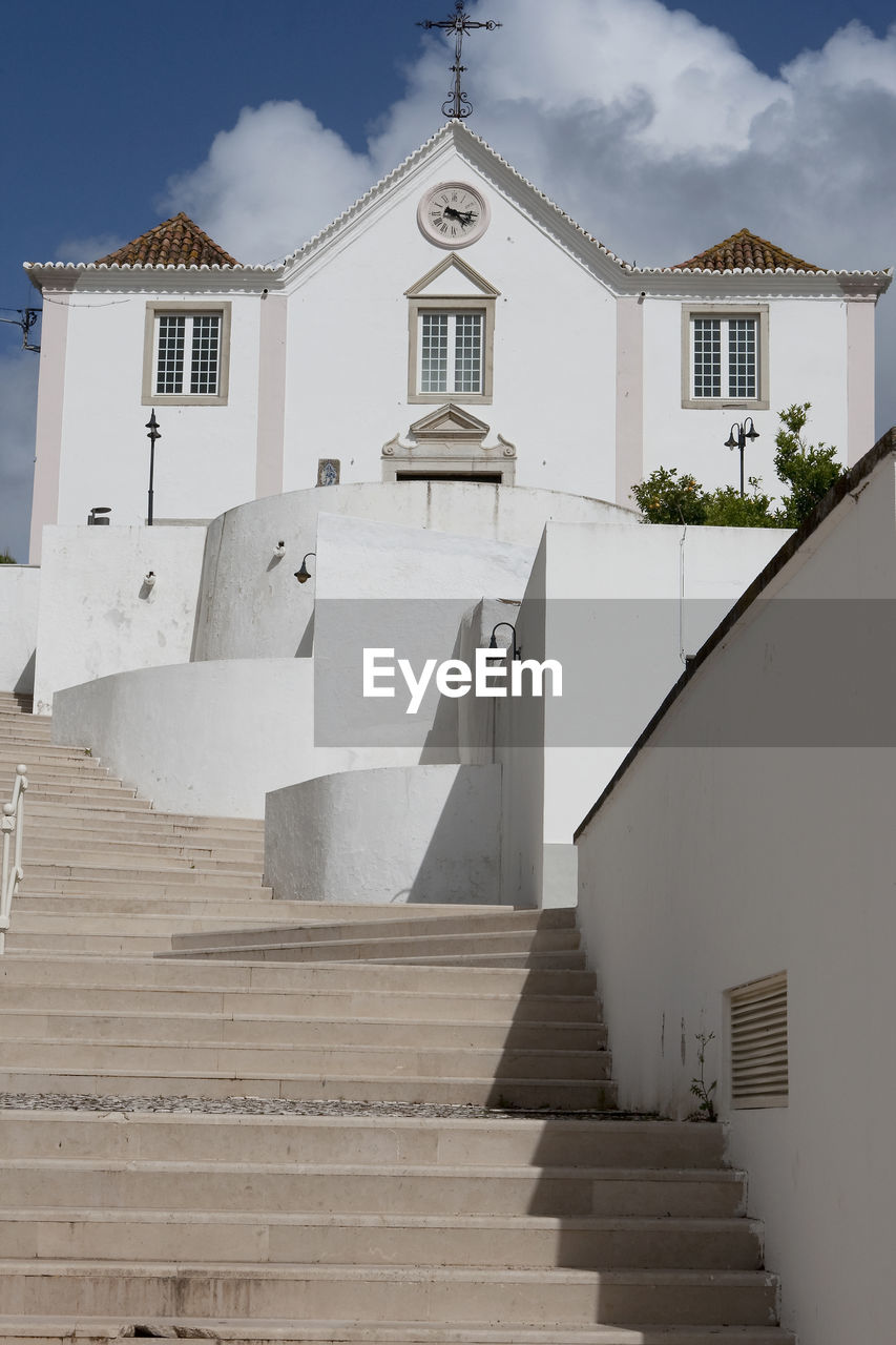 LOW ANGLE VIEW OF STEPS AMIDST BUILDINGS AGAINST SKY