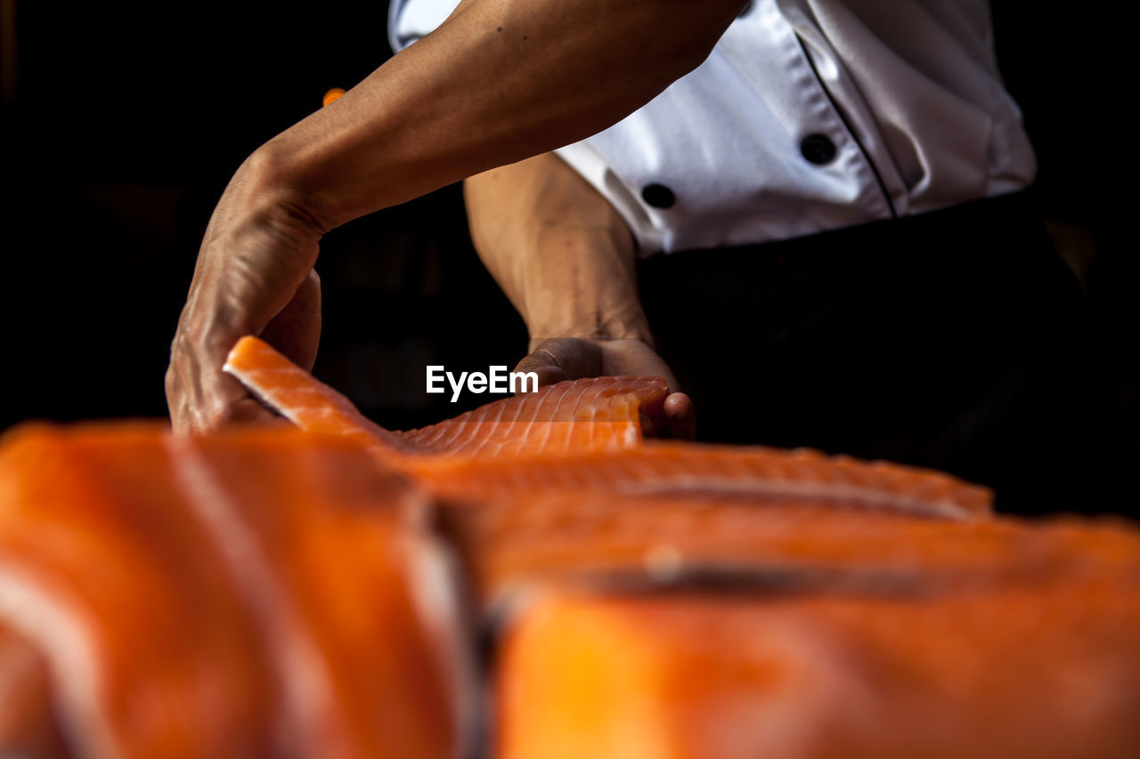 Midsection of man preparing food in commercial kitchen